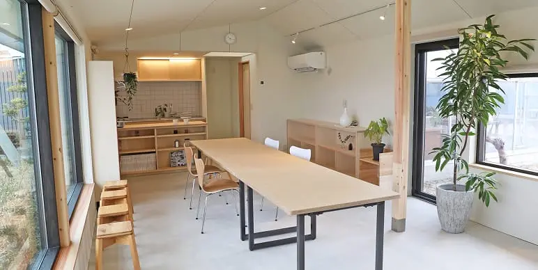 会議室のような木製テーブルと椅子が並ぶ室内